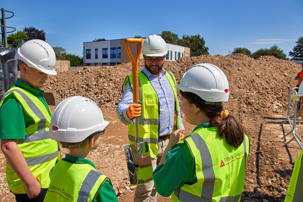 Tilbury Site Manager hands the spade to pupils